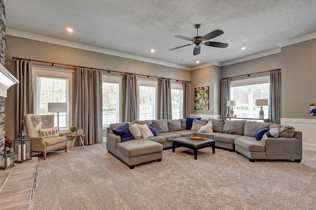 living area with recessed lighting, ceiling fan, ornamental molding, a textured ceiling, and light colored carpet