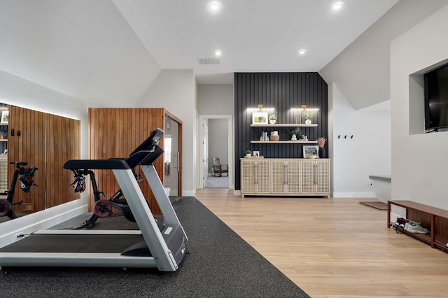 exercise room featuring baseboards, visible vents, lofted ceiling, recessed lighting, and light wood-type flooring