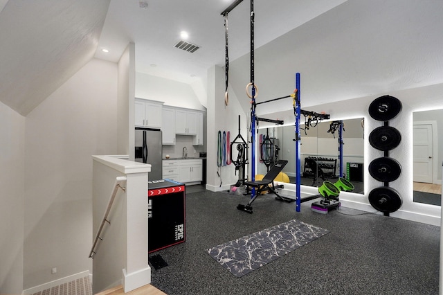 workout area featuring visible vents, baseboards, vaulted ceiling, recessed lighting, and a sink