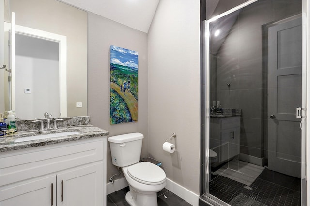 bathroom featuring vanity, a shower stall, toilet, and baseboards