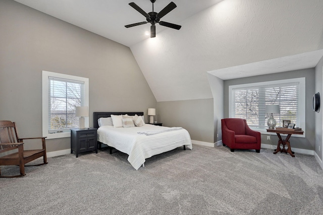 bedroom with vaulted ceiling, multiple windows, light colored carpet, and baseboards