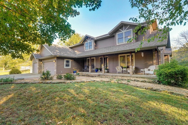 view of front of home with an attached garage, stone siding, a porch, and a front yard