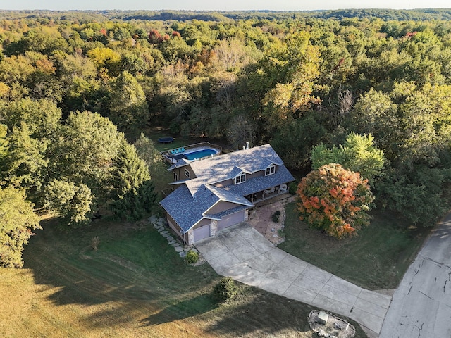 drone / aerial view featuring a wooded view