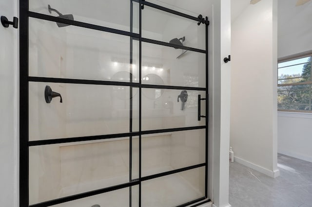 bathroom with marble finish floor, baseboards, and tiled shower