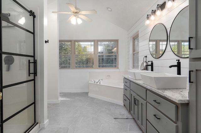 full bathroom featuring marble finish floor, a garden tub, a ceiling fan, vaulted ceiling, and vanity