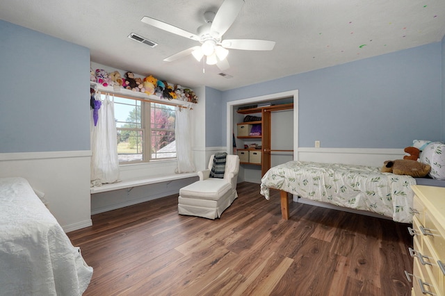 bedroom with dark wood-style floors, visible vents, and a ceiling fan