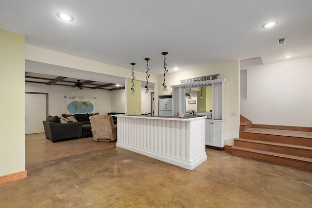 kitchen featuring concrete flooring, visible vents, white cabinets, open floor plan, and freestanding refrigerator