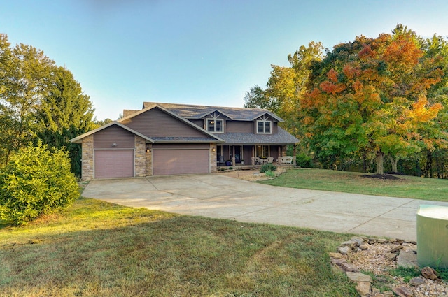 view of front of house featuring a garage, covered porch, stone siding, concrete driveway, and a front lawn