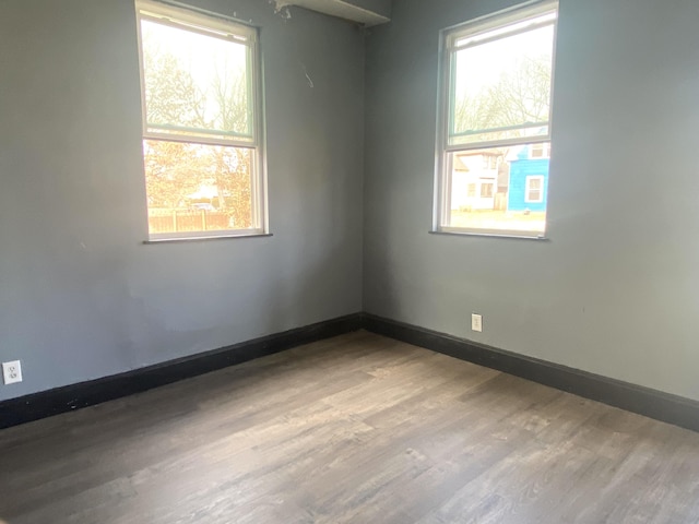 empty room featuring baseboards and wood finished floors