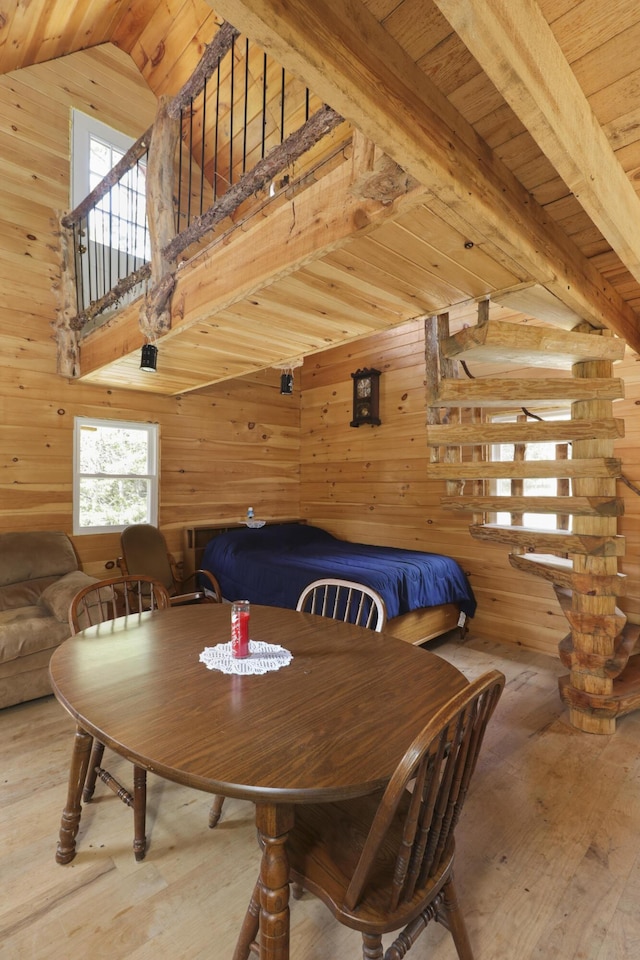 dining space with wood walls, wood ceiling, and hardwood / wood-style floors