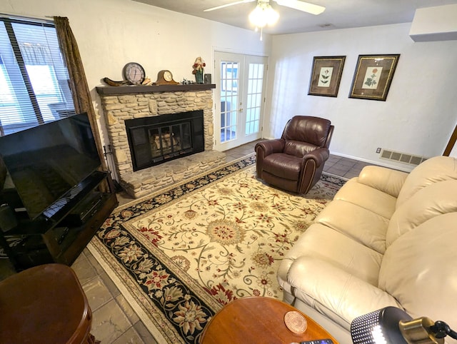 tiled living area featuring a ceiling fan, french doors, visible vents, and a fireplace