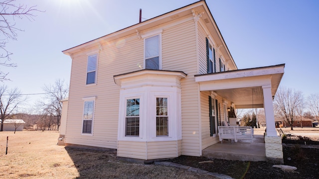 back of property with a porch