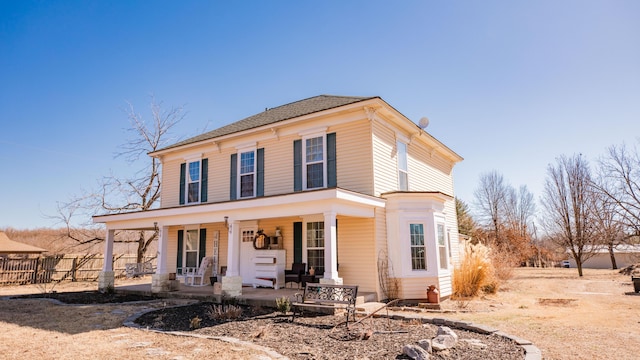 view of front of property with a porch and fence