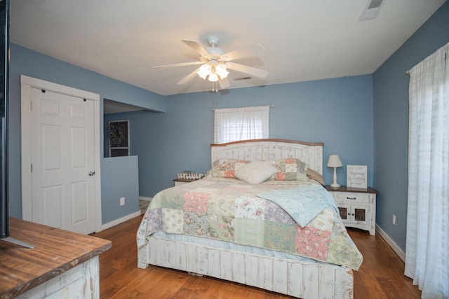 bedroom featuring wood finished floors, a ceiling fan, and baseboards