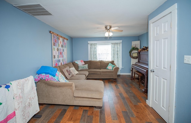 living area featuring ceiling fan, hardwood / wood-style floors, visible vents, and baseboards