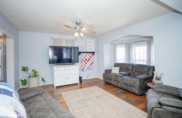 living room with a ceiling fan, dark wood finished floors, and baseboards