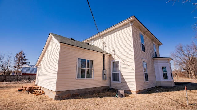 back of house with a shingled roof