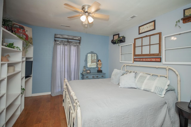 bedroom with dark wood-style floors, visible vents, and a ceiling fan