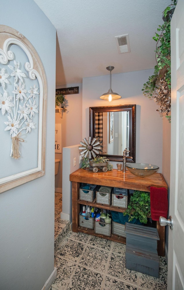 tiled dining area with baseboards, visible vents, and a sink