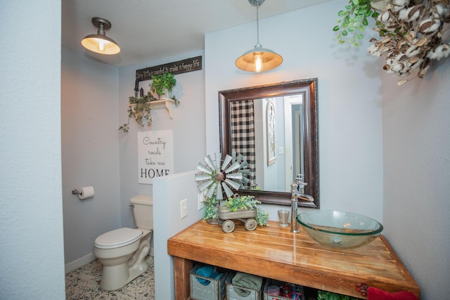 bathroom with toilet, baseboards, and vanity