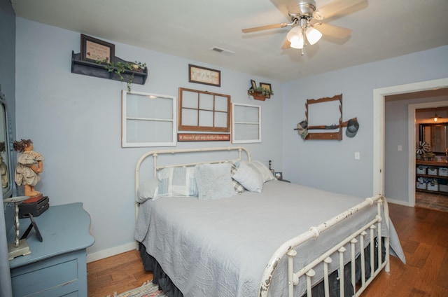 bedroom featuring visible vents, ceiling fan, baseboards, and wood finished floors