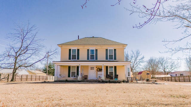 view of front of home featuring covered porch and fence