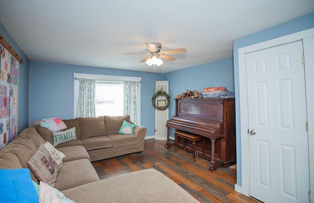 living area with a ceiling fan, baseboards, and wood finished floors