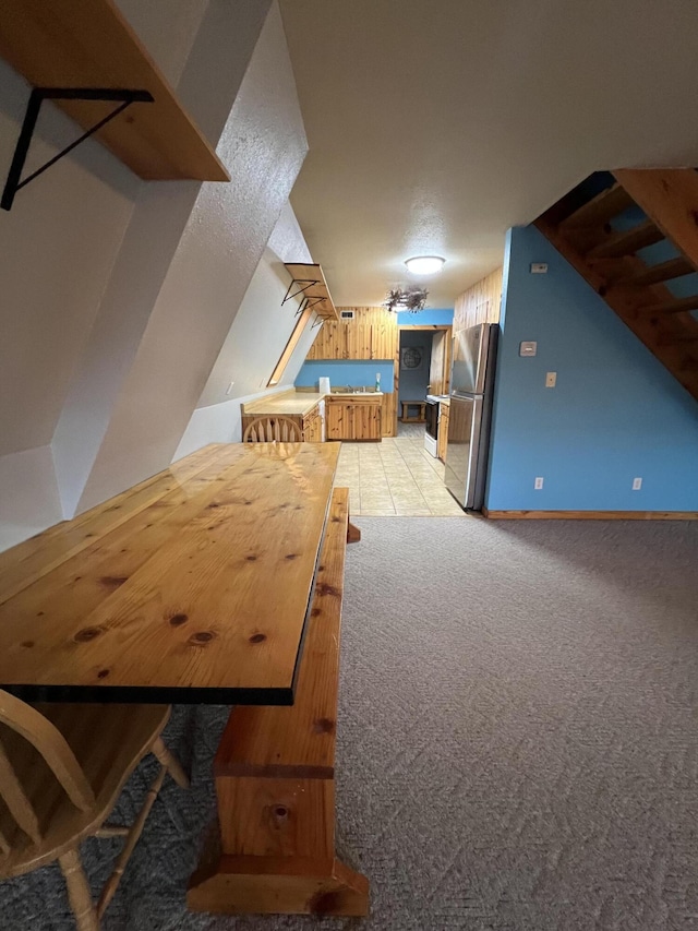 bonus room with light carpet, lofted ceiling, and baseboards