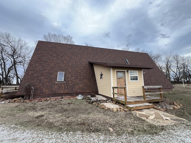 view of front of home with a shingled roof and a wooden deck