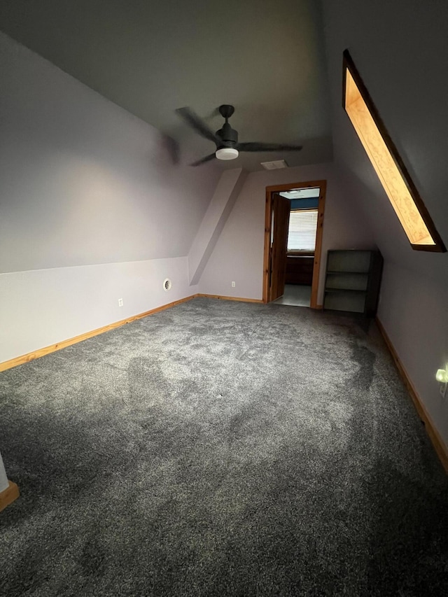 additional living space featuring vaulted ceiling, carpet flooring, a ceiling fan, and baseboards