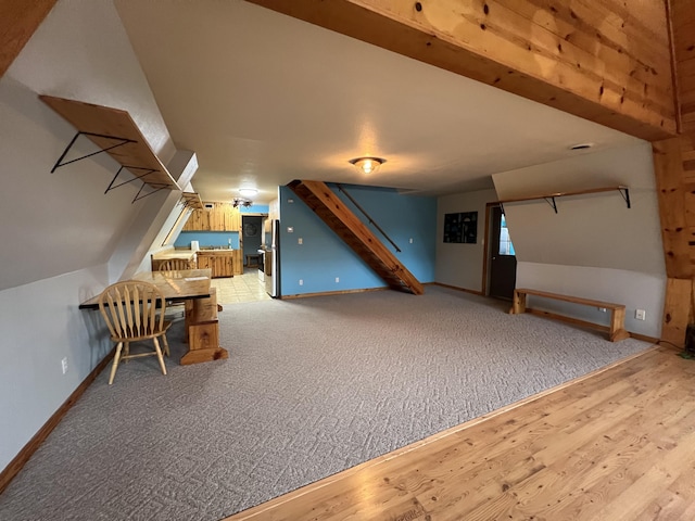 bonus room with baseboards, lofted ceiling, stairway, wood finished floors, and carpet flooring