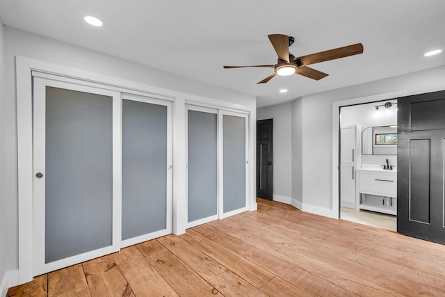 unfurnished bedroom featuring light wood-type flooring, two closets, and recessed lighting