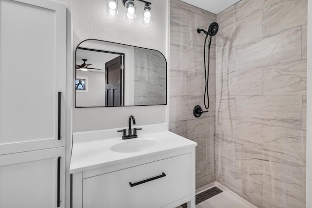 full bath featuring tiled shower and vanity