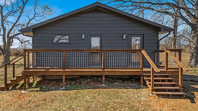 back of property with a deck and stairway