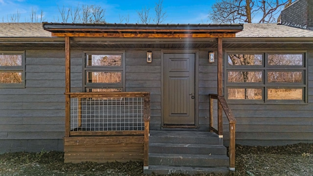 entrance to property with roof with shingles