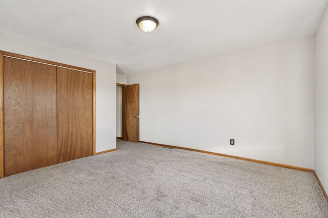 unfurnished bedroom featuring a closet, carpet, and baseboards