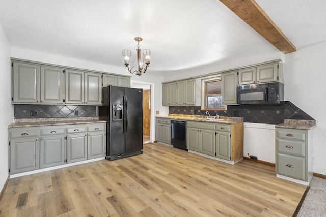 kitchen featuring gray cabinetry, a sink, light wood-style flooring, and black appliances