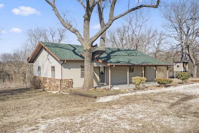 view of front of home featuring covered porch and a shingled roof