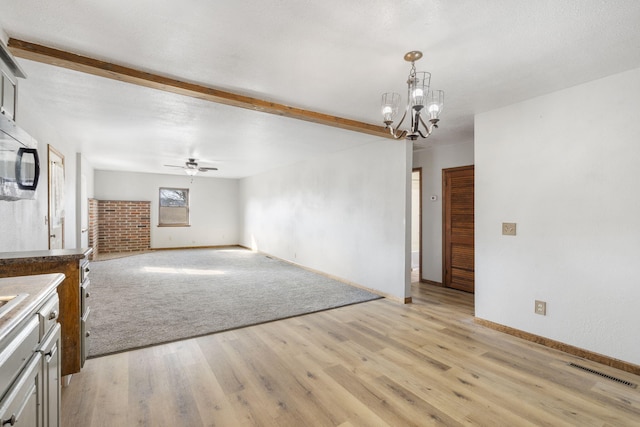 interior space featuring beam ceiling, visible vents, light wood-style flooring, and ceiling fan with notable chandelier