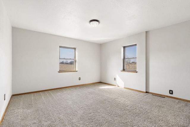 unfurnished room featuring baseboards, carpet flooring, and a healthy amount of sunlight