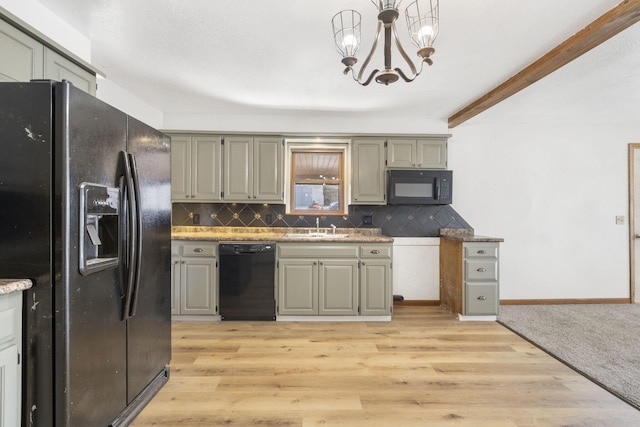 kitchen with black appliances, light wood-style flooring, decorative backsplash, and a sink