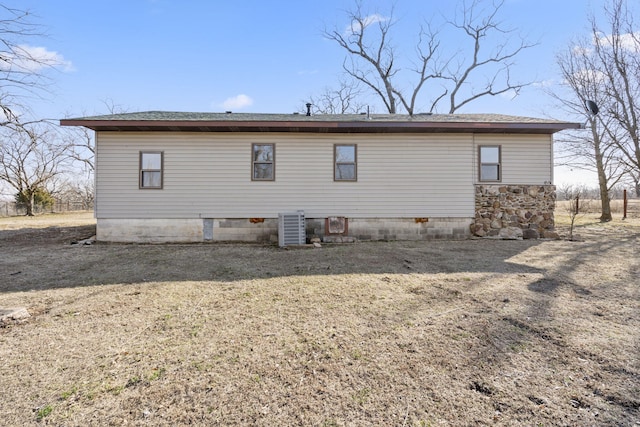 back of house featuring central AC unit and a shingled roof