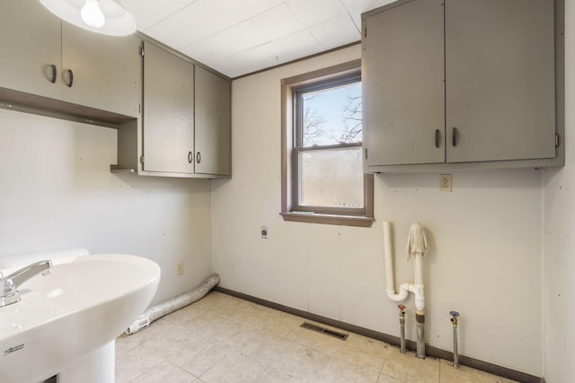 laundry area with electric dryer hookup, a sink, visible vents, and baseboards