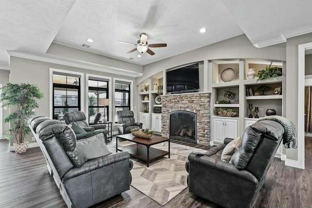 living room with crown molding, a fireplace, visible vents, wood finished floors, and baseboards