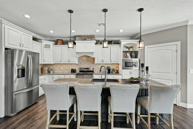 kitchen with white cabinets, decorative backsplash, dark wood-type flooring, stainless steel appliances, and a sink