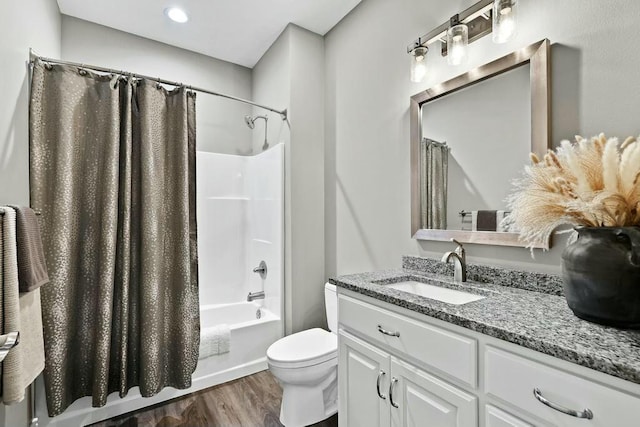 bathroom featuring toilet, shower / tub combo with curtain, wood finished floors, and vanity