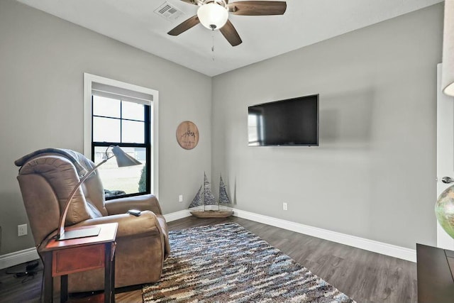 living area with a ceiling fan, baseboards, visible vents, and wood finished floors