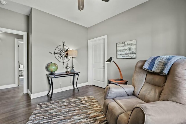 sitting room featuring a ceiling fan, baseboards, and dark wood-style flooring