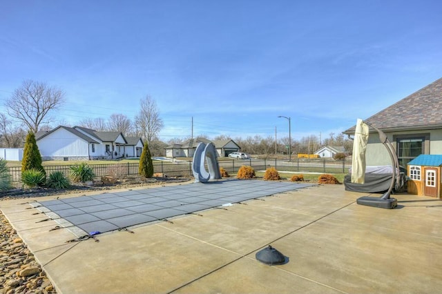 view of swimming pool featuring fence private yard, a patio area, a residential view, and a water slide