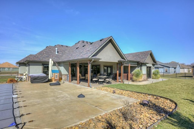 back of house featuring a yard, a patio area, fence, and stucco siding